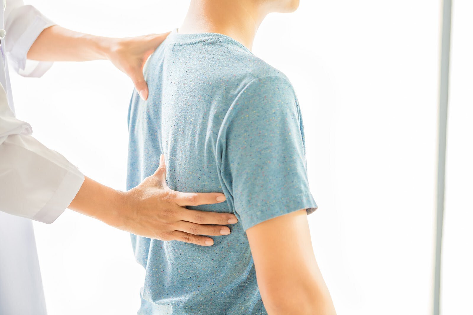 Phoenix back pain treatment model wearing a green shirt