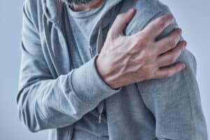 Shoulder joint pain, man with severe ache as symptom of osteoart