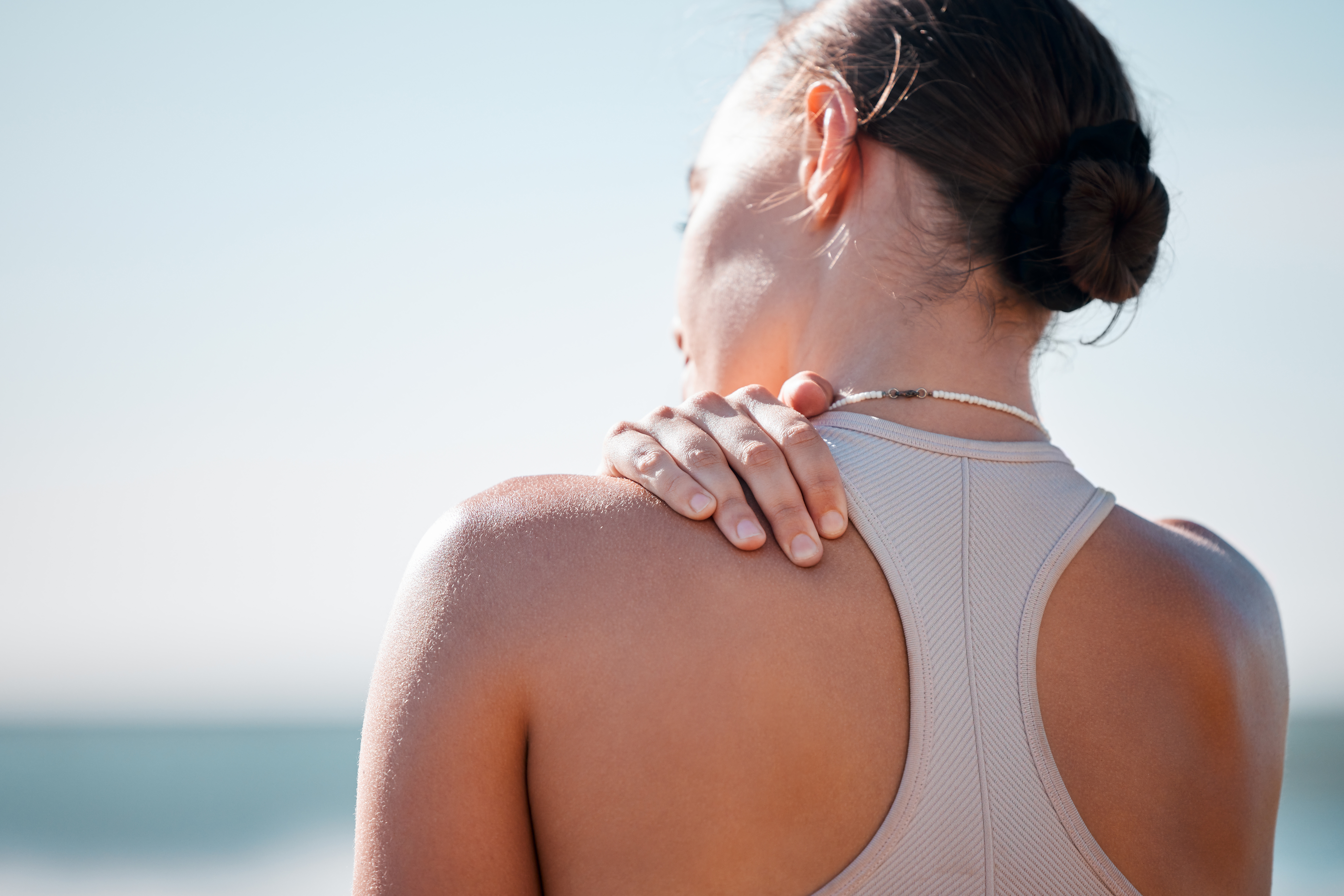 tired shoulder pain and fitness with woman at bea 2025 04 06 08 45 08 utc